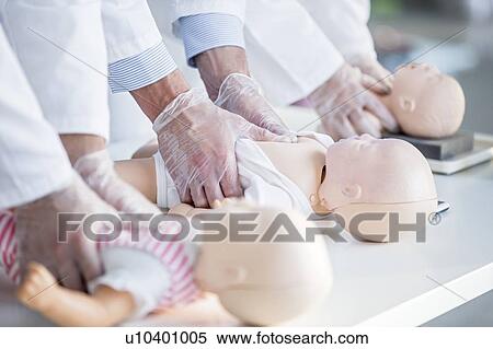 Doctors practising chest compressions on an infant CPR training dummy. View Large Photo Image Stock Photography - Doctors practising chest compressions on an infant CPR training dummy.. Fotosearch