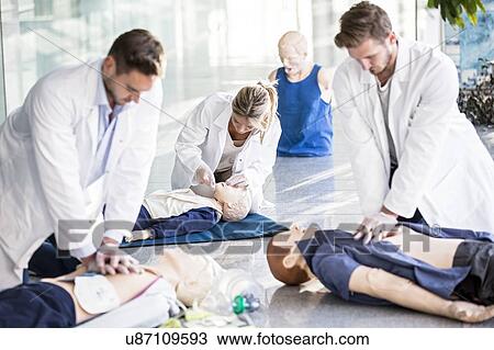 Doctors undertaking CPR training on dummies. View Large Photo Image Stock Image - Doctors undertaking CPR training on dummies.. Fotosearch