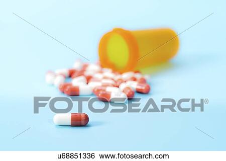 Stock Photograph - Drug capsules spilling from bottle.. Fotosearch