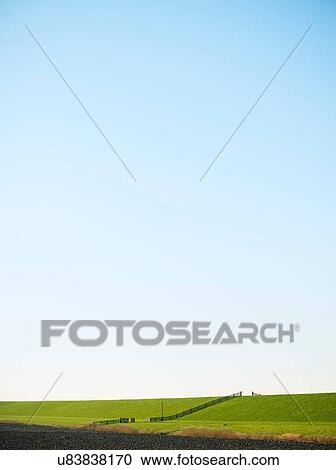 Stock Image - Dyke along the wadden sea on a winter day, Holwerd, Friesland, Netherlands. Fotosearch
