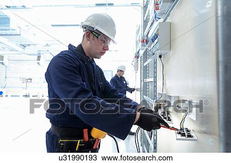 Stock Image - Electrical engineers testing electrical equipment. Fotosearch
