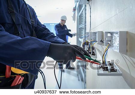 Stock Photo - Electrical engineers testing electrical equipment. Fotosearch
