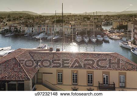Stock Photo - Elevated view of rooftops and yachts moored on waterfront in Grimaud, Provence-Alpes-Cote d'Azur, France. Fotosearch