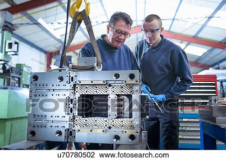 Engineer and apprentice working on mould for plastic injection in precision engineering factory View Large Photo Image Stock Image - Engineer and apprentice working on mould for plastic injection in precision engineering factory. Fotosearch