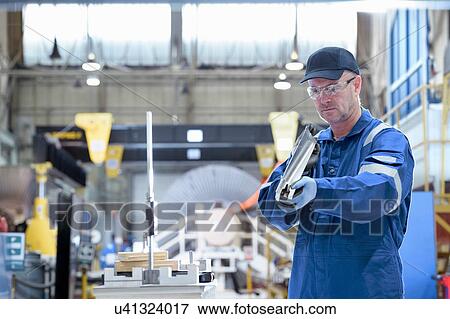 Engineer inspecting turbine blade in turbine maintenance factory View Large Photo Image Stock Photo - Engineer inspecting turbine blade in turbine maintenance factory. Fotosearch