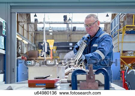 Engineer inspecting turbine blade in turbine maintenance factory View Large Photo Image Stock Photograph - Engineer inspecting turbine blade in turbine maintenance factory. Fotosearch