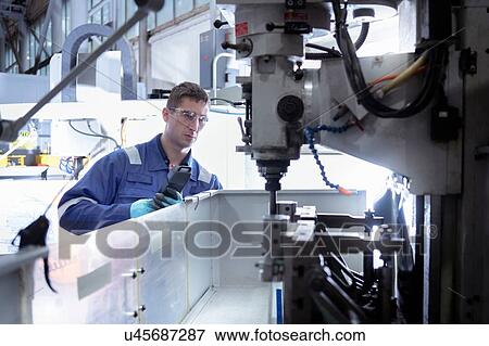 Engineer looking into lathe in turbine maintenance factory View Large Photo Image Stock Photo - Engineer looking into lathe in turbine maintenance factory. Fotosearch