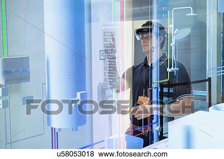 Engineer using augmented reality headset to 'see' utilities through walls in robotics research facility View Large Photo Image Stock Photo - Engineer using augmented reality headset to 'see' utilities through walls in robotics research facility. Fotosearch