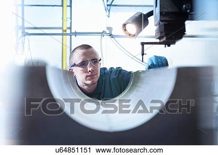 Stock Image - Engineer using electrical discharge (EDM) to drill holes in metal in precision engineering factory. Fotosearch