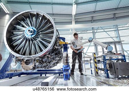 Engineer using robotic metrology to measure jet engine in robotics research facility View Large Photo Image Stock Photograph - Engineer using robotic metrology to measure jet engine in robotics research facility. Fotosearch