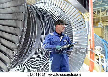 Stock Photography - Engineer with turbine blade in turbine maintenance factory. Fotosearch