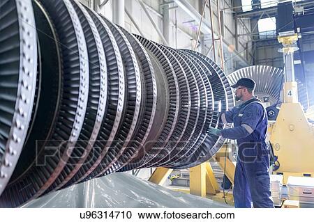 Stock Image - Engineer working on high pressure steam turbine in turbine maintenance factory. Fotosearch