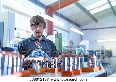 Stock Photo - Engineer working with electrodes for electrical discharge machine in precision engineering factory. Fotosearch