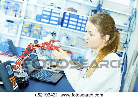 Stock Image - Engineer working with robotic arm.. Fotosearch