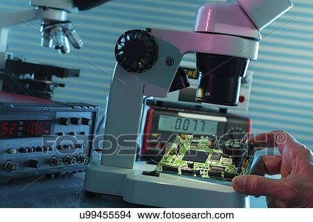 Examining circuit board with microscope. View Large Photo Image Picture - Examining circuit board with microscope.. Fotosearch
