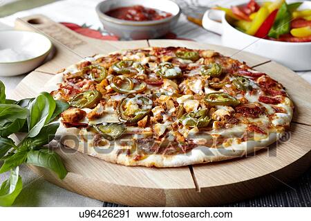Stock Image - Fajita pizza on wooden pizza board, close-up. Fotosearch