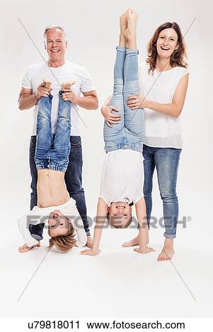Stock Image - Family portrait with children held upside down. Fotosearch