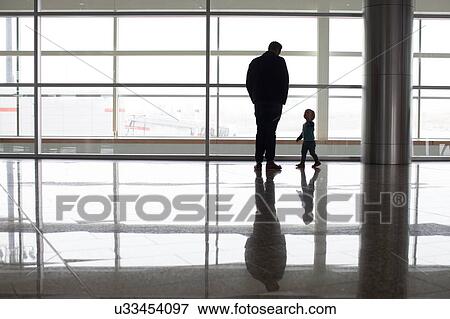 Father and son beside window at airport, Alberta, Canada View Large Photo Image Stock Photo - Father and son beside window at airport, Alberta, Canada. Fotosearch
