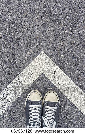 Stock Photograph - Feet and road markings.. Fotosearch