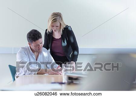 Stock Photograph - Female and male scientists signing contract about pharmaceutical project in meeting room. Fotosearch