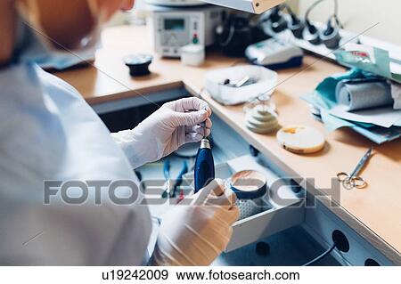 Female dentist handling dentistry equipment in dentist office, mid section View Large Photo Image Stock Photo - Female dentist handling dentistry equipment in dentist office, mid section. Fotosearch