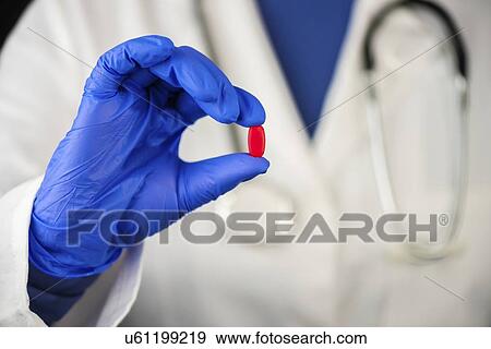Stock Photo - Female doctor offering red pill.. Fotosearch