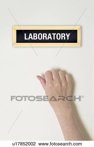 Stock Image - Female hand knocking on laboratory door, conceptual image.. Fotosearch