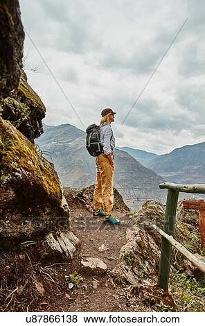Stock Photo - Female hiker looking out at distant mountains, Pisac, Cusco, Peru. Fotosearch