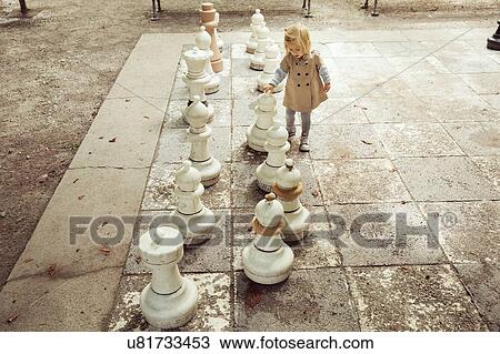 Female toddler playing with giant chess in park View Large Photo Image Stock Image - Female toddler playing with giant chess in park. Fotosearch