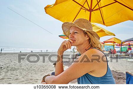 Female tourist sitting under beach umbrella, Camana, Arequipa, Peru View Large Photo Image Stock Photo - Female tourist sitting under beach umbrella, Camana, Arequipa, Peru. Fotosearch
