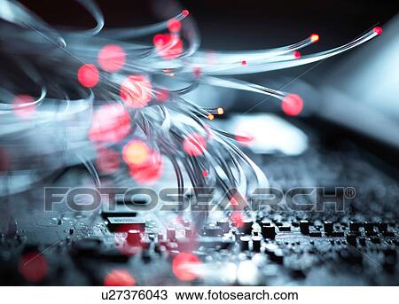 Stock Image - Fibre optics carrying data passing the inside circuit boards of a laptop computer. Fotosearch