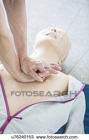 First-aider practising chest compressions on a CPR training dummy. View Large Photo Image Stock Image - First-aider practising chest compressions on a CPR training dummy.. Fotosearch