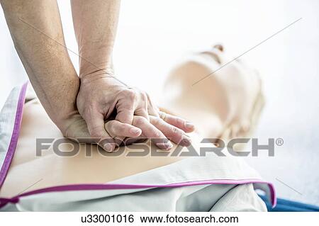 First-aider practising chest compressions on a CPR training dummy. View Large Photo Image Stock Photograph - First-aider practising chest compressions on a CPR training dummy.. Fotosearch