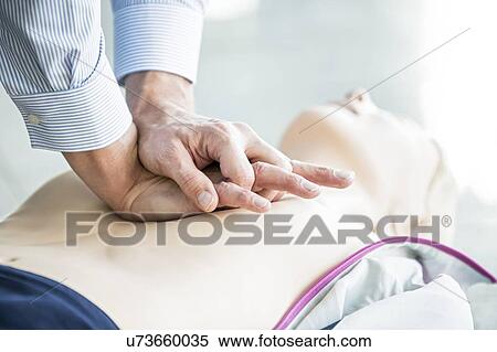 First-aider practising chest compressions on a CPR training dummy. View Large Photo Image Stock Photography - First-aider practising chest compressions on a CPR training dummy.. Fotosearch
