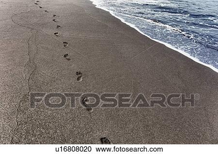 Stock Image - Footprints in sand on coastline, Sao Filipe, Fogo, Cape Verde, Africa. Fotosearch
