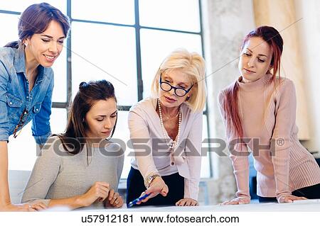 Four women in business meeting, looking at document View Large Photo Image Stock Image - Four women in business meeting, looking at document. Fotosearch