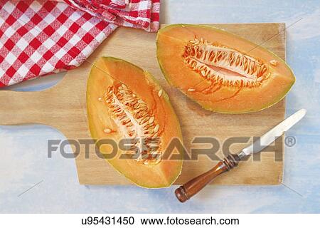 Stock Image - Fresh melon quarters on a table.. Fotosearch