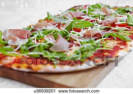 Fresh pizza with rocket and parma ham on chopping board View Large Photo Image Stock Image - Fresh pizza with rocket and parma ham on chopping board. Fotosearch