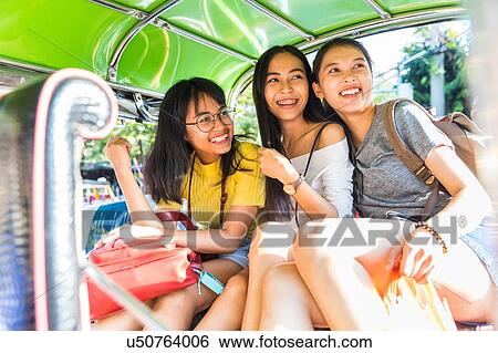 Stock Photograph - Friends sightseeing in tuk tuk car, Bangkok, Thailand. Fotosearch