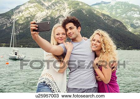 Stock Image - Friends taking selfie, Innsbruck, Tirol, Austria, Europe. Fotosearch