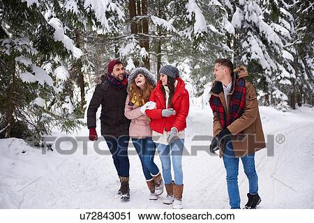 Stock Image - Friends walking and laughing in snow. Fotosearch
