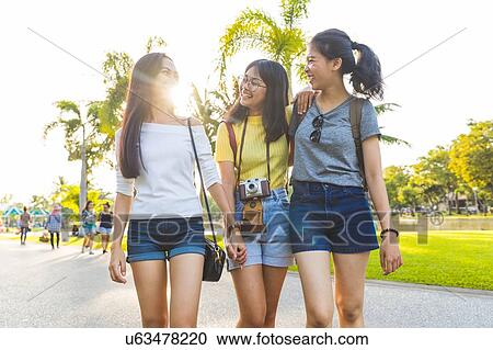 Stock Image - Friends walking and sightseeing in park, Bangkok, Thailand. Fotosearch
