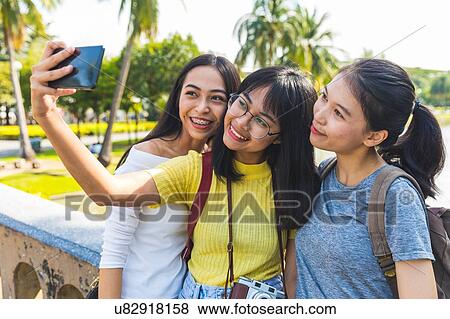 Stock Photo - Friends walking and sightseeing in park, Bangkok, Thailand. Fotosearch