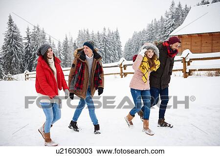 Stock Image - Friends walking in snow. Fotosearch