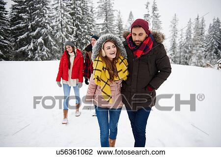 Friends walking in snow View Large Photo Image Stock Image - Friends walking in snow. Fotosearch