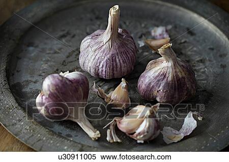 Stock Photography - Garlic bulbs on tray. Fotosearch