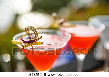 Stock Photograph - Garnished cocktails in cocktail glasses. Fotosearch