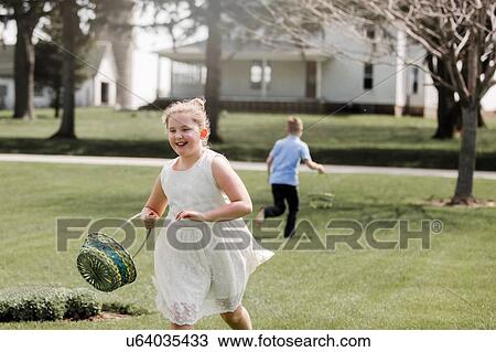 Girl and boy outdoors, holding Easter baskets, on Easter egg hunt View Large Photo Image Stock Image - Girl and boy outdoors, holding Easter baskets, on Easter egg hunt. Fotosearch