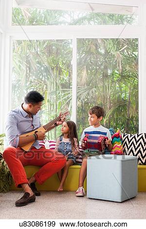Girl and boy practicing music with teacher on window seat View Large Photo Image Stock Photo - Girl and boy practicing music with teacher on window seat. Fotosearch