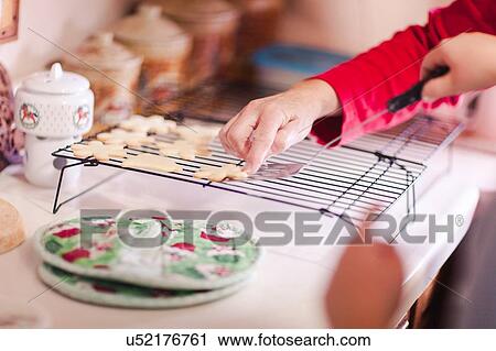 Girl and grandmother placing cookie on baking tray, hands View Large Photo Image Stock Image - Girl and grandmother placing cookie on baking tray, hands. Fotosearch